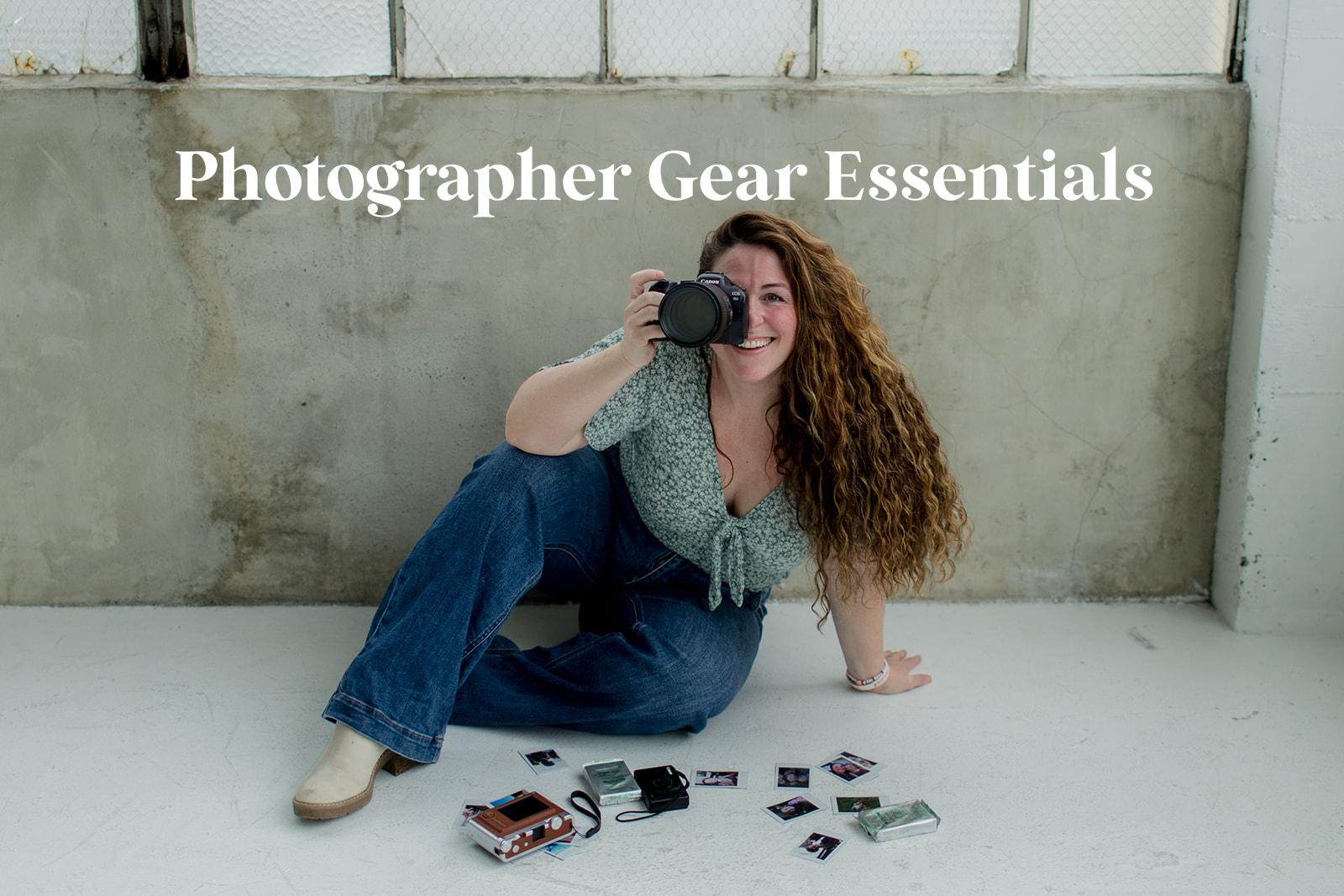 Photographer on the floor with her camera in hand with polaroid prints scattered around with the title in white letters saying "Photographer Gear Essentials"